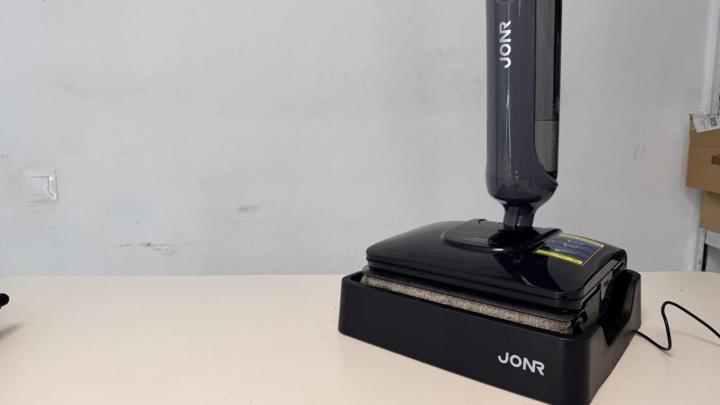 JONR H2 Pro de pie sobre su base de carga y autolimpieza, con el rodillo secándose en la base